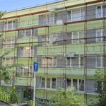 Nátěr fasády panelového domu zelenou barvou Prachatice